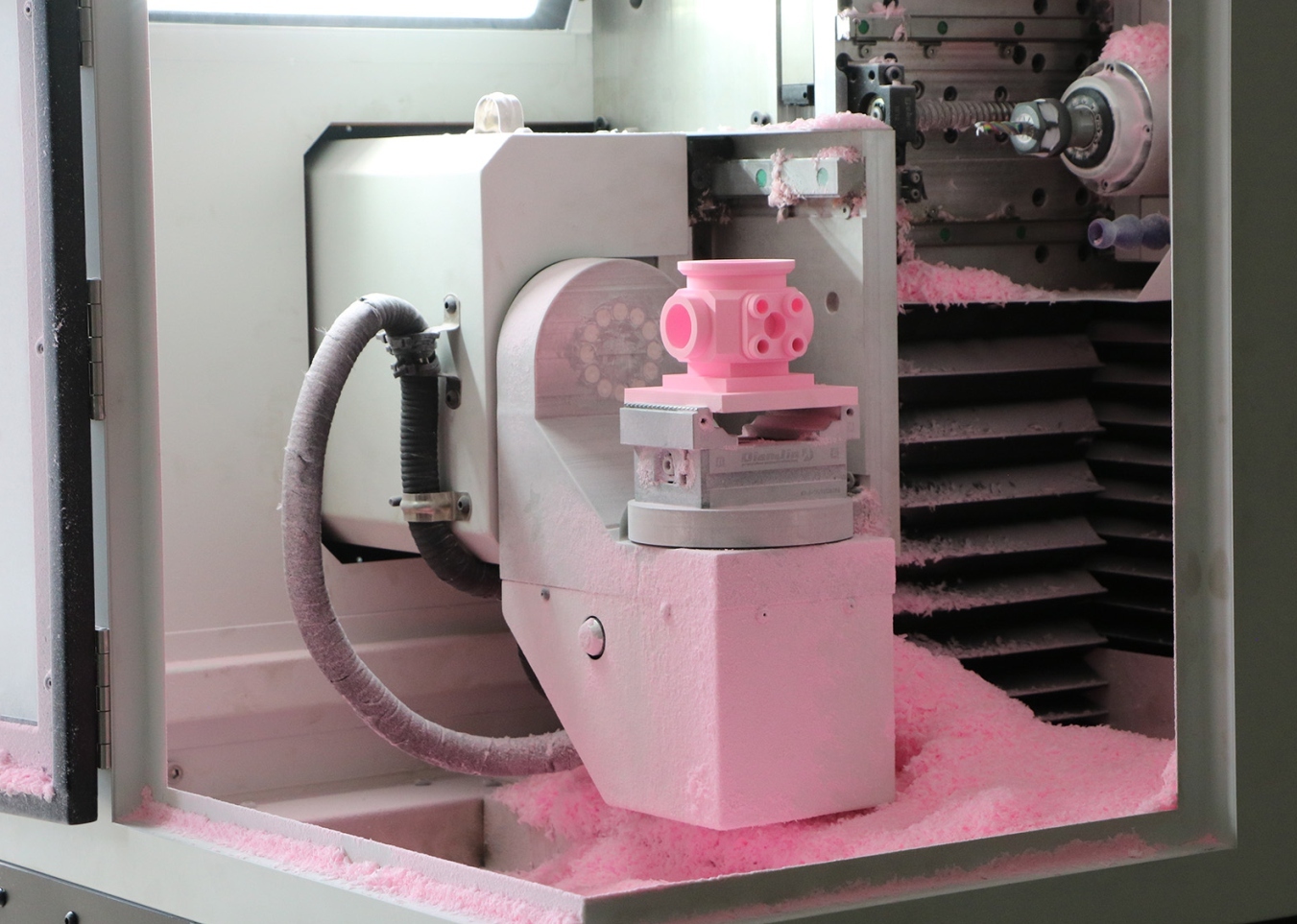 Engineering plastic part being machined on the five-axis trunnion